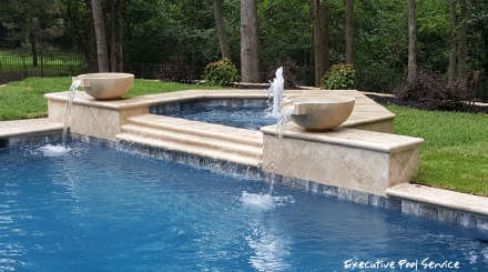 photo of McKinney pool remodel replaster mediterranean blue exposed quartz re-plaster, travertine coping and water bowls by Executive Pool Service McKinney Tx.